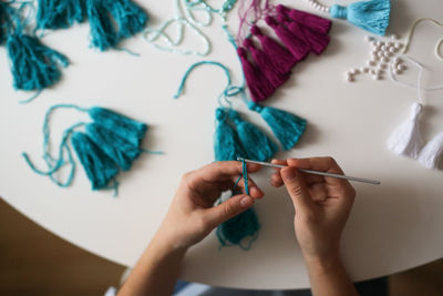 Woman working with threads and beads close-up, concept creativity, hobby and small business.