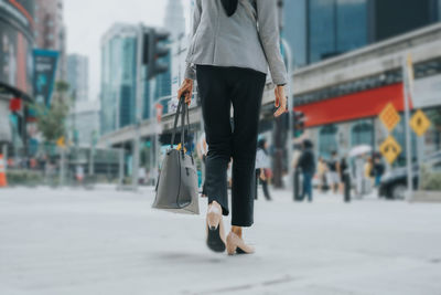 Low section of woman walking on street