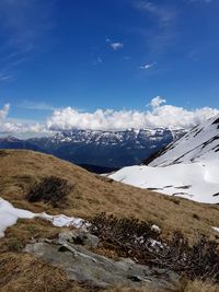 Scenic view of snowcapped mountains against blue sky