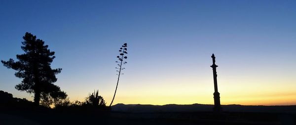 Silhouette landscape against clear sky during sunset