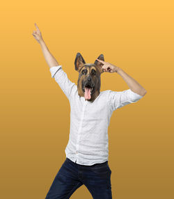 Portrait of woman standing against yellow background