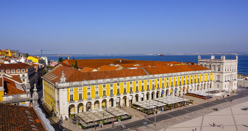 High angle view of buildings by sea against clear sky