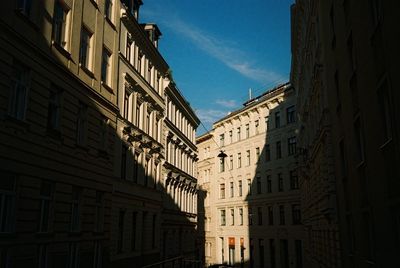 Low angle view of buildings in town against blue sky