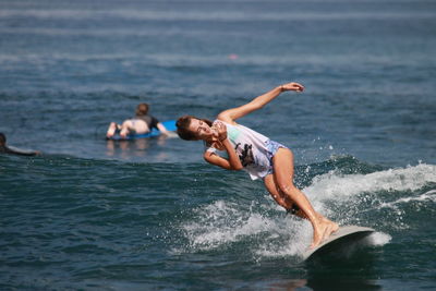 Full length of woman surfing in sea