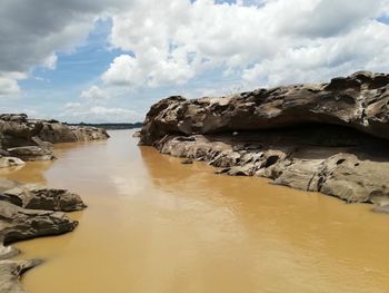 Panoramic shot of rocks on beach against sky