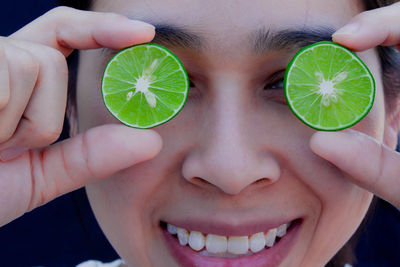 Close-up portrait of woman holding lemon slices 