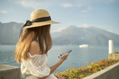 Woman using mobile phone against mountains