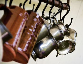 Low angle view of cups hanging on hooks in kitchen