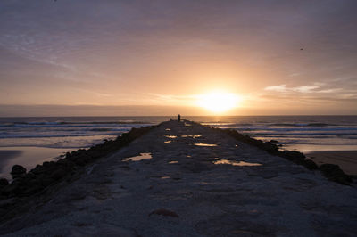 Scenic view of beach against sky during sunset