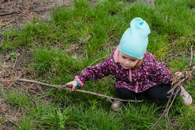 The child collects dry branches from the grass. the concept of caring for the environment. 