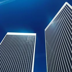 Low angle view of modern buildings against clear blue sky