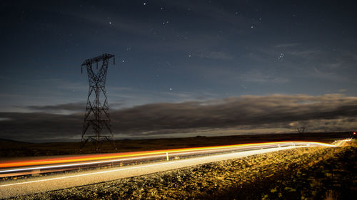 Light trails on road against sky at night