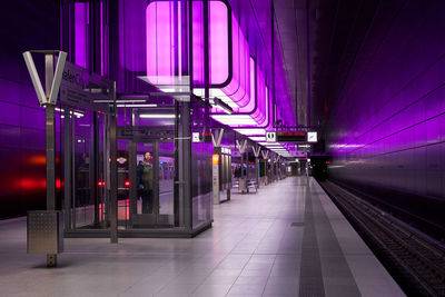 Illuminated railroad station platform at night