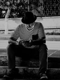 Full length of young man sitting on seat