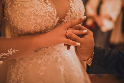 Midsection of bride holding wedding dress