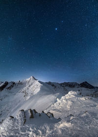 Scenic view of snowcapped mountains against sky at night