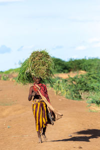 Rear view of woman walking on field