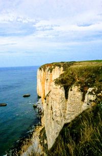 Rock formations by sea against sky