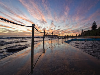 Scenic view of suspension bridge over sea against sky