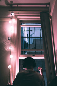 Rear view of man seen through glass window