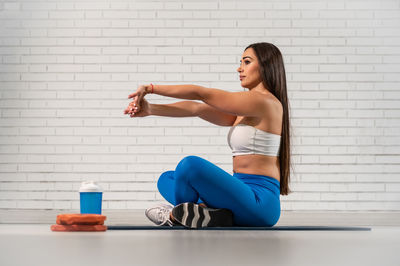 A pretty caucasian woman doing stretching in the gym