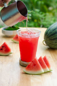 Watermelon juice in the glass on wooden table.