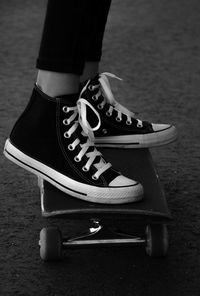 Low section of person wearing canvas shoes on skateboard