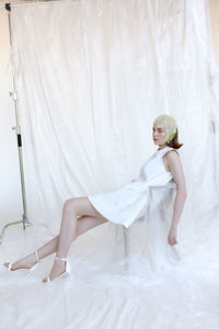 Young woman with umbrella against white background
