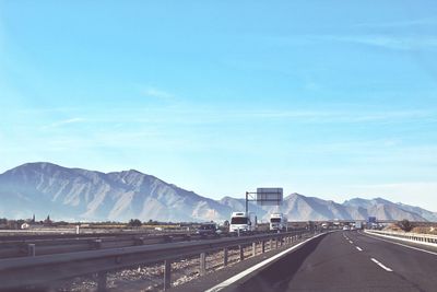 Road by mountains against blue sky