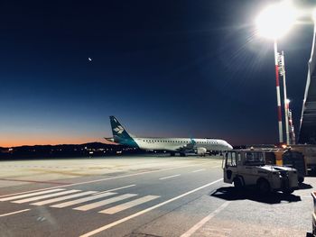 Airplane on airport runway against sky