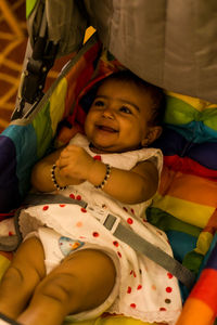 Portrait of cute baby girl lying on sofa
