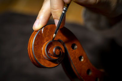 Young chinese violin maker at work in her workshop