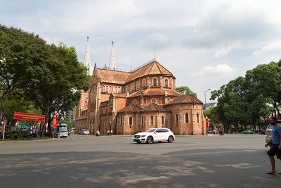 Cars on street against sky in city