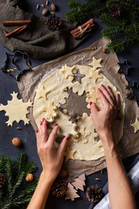 Christmas baking at home. female hands making snowflake cookies from fresh dough. view from above