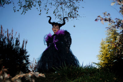 Girl with maleficent costume playing in the woods