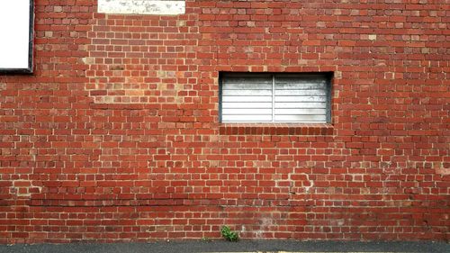 Red window on brick wall