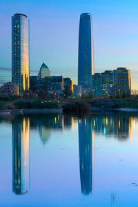 Reflection of illuminated buildings in lake at dusk