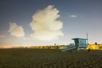 Lifeguard hut at beach against sky during sunset