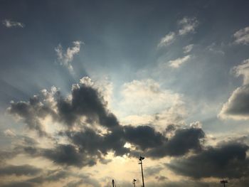 Low angle view of silhouette communications tower against sky