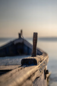 Close-up of wooden rowboat in lake during sunset