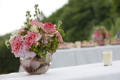 Flowers in glass vase on retaining wall