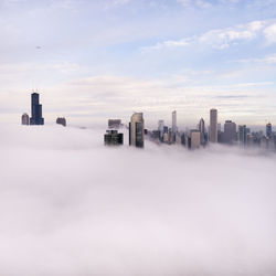 Aerial view of cityscape during against cloudy sky foggy weather