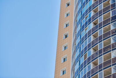 Low angle view of modern building against clear blue sky