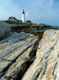 Lighthouse by sea against sky