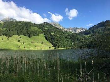 Scenic view of lake by mountains against sky