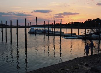 Silhouette man standing by sea against sky during sunset