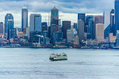 Nautical vessel on sea against modern buildings in city