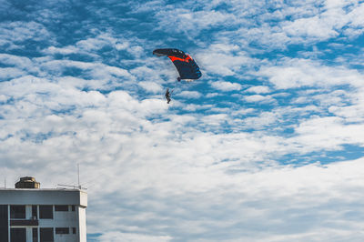 Low angle view of person paragliding against sky