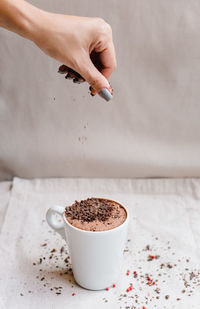 Hand holding coffee cup on table