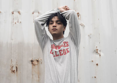 Portrait of boy standing against wall